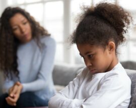 Child sulking with adult behind