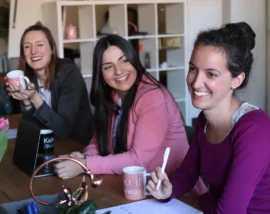 Group of friends round table laughing
