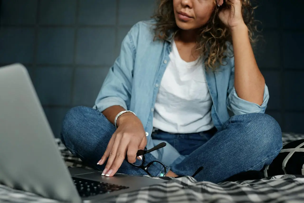 Woman sat on bed on laptop